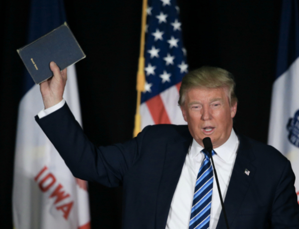 Trump lifts bible to crowd.