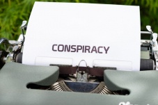 The word &#034;conspiracy&#034; typewritten on a piece of paper