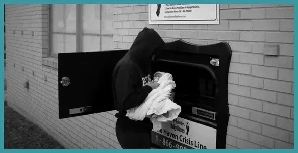 A woman putting a baby inside the Safe Haven Baby Box