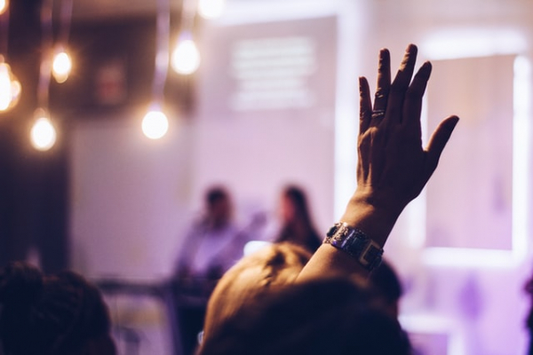 Christian raising hand in worship of God in church