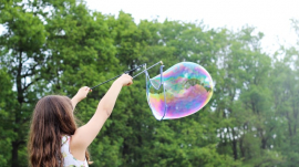 girl making bubbles during daytime