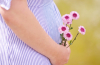 pregnant mom holding flowers near her tummy