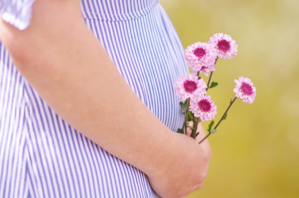 pregnant mom holding flowers near her tummy