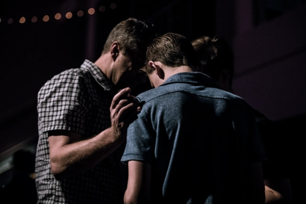Minister praying for a man in church