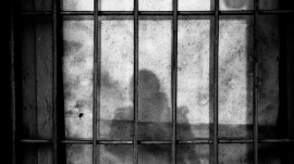 anonymous person behind bars in jail prison