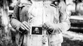 pregnant mom holding small ultrasound photo of her baby