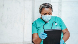 nurse in scrubs holding a file 