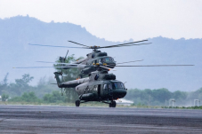 Military commando helicopters landing on asphalt ground