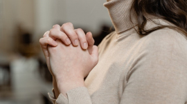 woman praying with her hands clasped