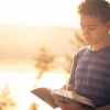 youth reading his Bible outdoors