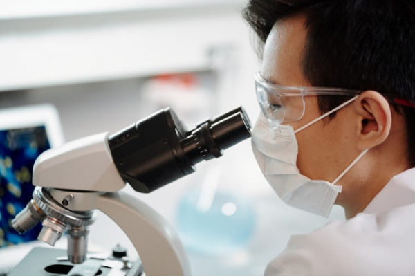 medical technologist examining a sample using a microscope