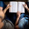 husband and wife married couple reading Bible together