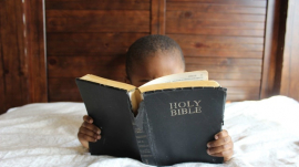 child reading Bible