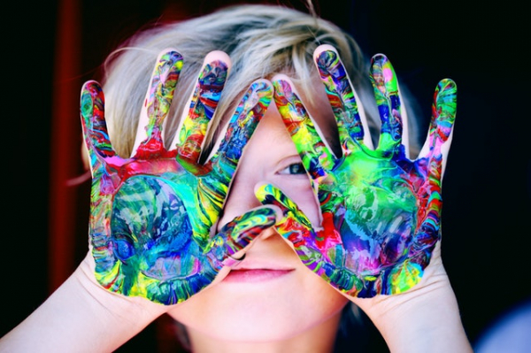 child playing with paint on the hands