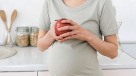 pregnant mom holding apple in her hands