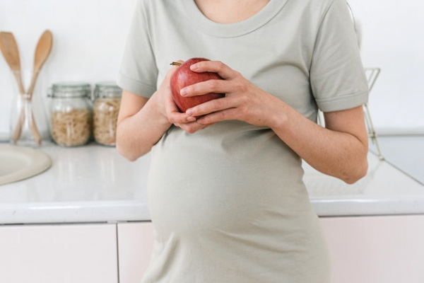 pregnant mom holding apple in her hands
