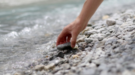 picking up stones from the edge of the waters