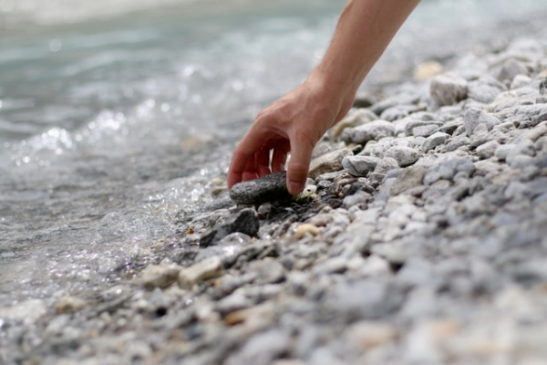 picking up stones from the edge of the waters
