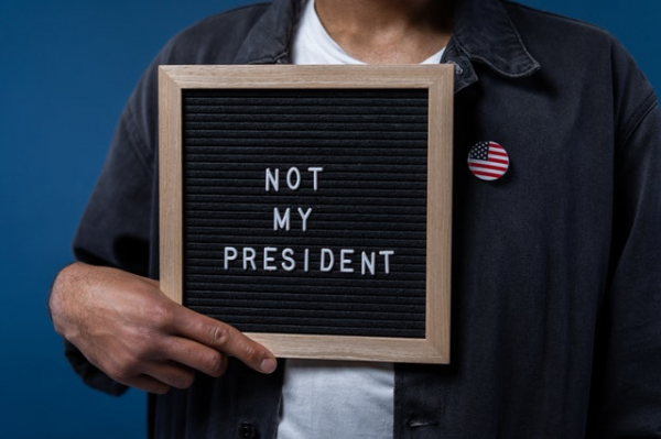man holding sign saying "not my president"